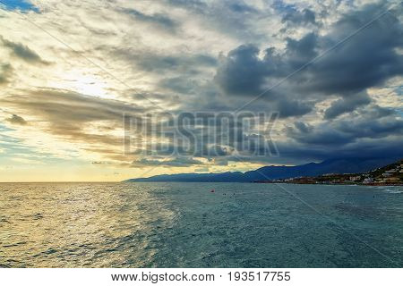 Sunset with clouds and sea waves, Crete, Greece