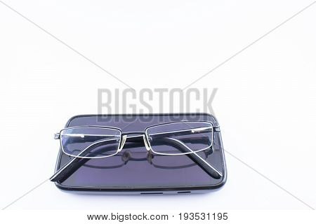 Glasses with increase on a cell phone. White background.