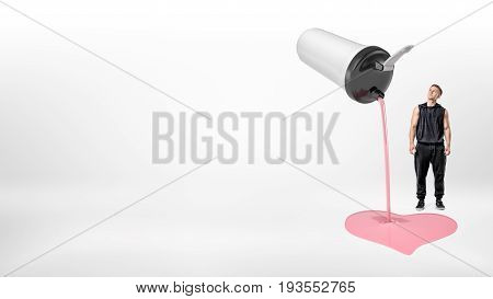 A small muscular man in black sportswear looking up to a giant white shaker that's leaking pink yogurt. Healthy diet. Gainers and powders. Vitamin intake.