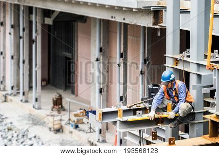 TAIPEI TAIWAN - May 20 2017 : Construction worker sit on steel bars and measure the level in Taipei xinyi district