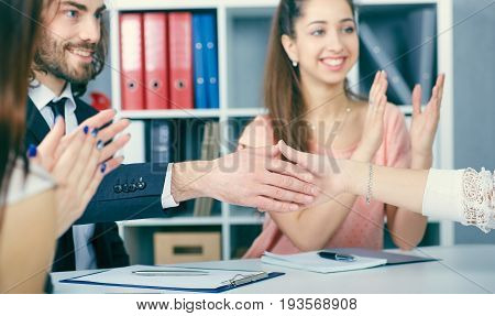 Male and female handshake in office. Serious business and partnership concept. Partners made deal sealed with handclasp.