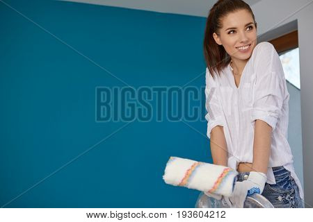 Beautiful young woman doing wall painting