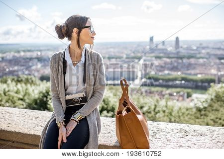 Young woman with photocamera enjoying great view on Lyon city during the morning in France