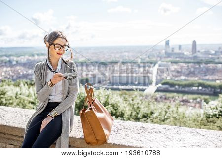 Young woman with photocamera enjoying great view on Lyon city during the morning in France