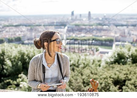 Young woman with photocamera enjoying great view on Lyon city during the morning in France