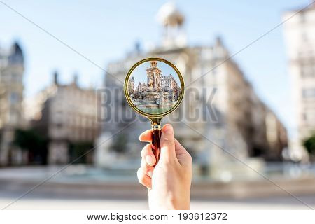 Holding a magnifying glass focused on famous Jacobins fountain in Lyon city in France