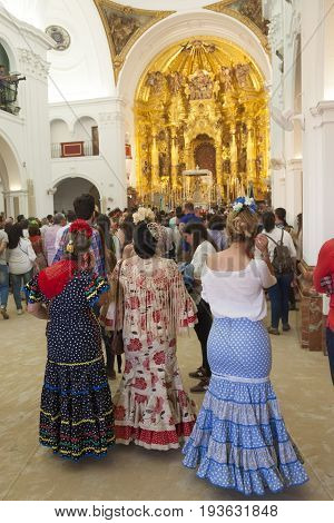 El Rocio Spain - June 2 2017: Pilgrims in traditional spanish dress in the hermitage of El Rocio during the Romeria 2017. Andalusia Spain