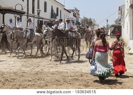 El Rocio Spain - June 2 2017: Group of pilgrims on horseback in traditional spanish dress in El Rocio during the Romeria 2017. Province of Huelva Almonte Andalusia Spain
