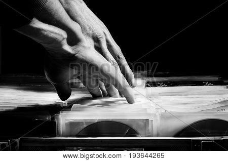 Illegal pirated market of compact disc with music and movies downloaded from the internet. Black and white. Crime concept. CD pirate sale.