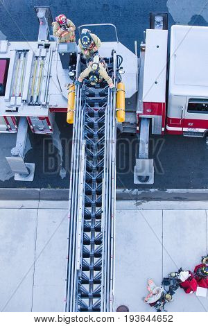 Firefighter Training Entering And Exiting A Building On A Truck Ladder Overhead View
