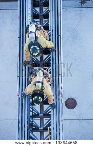 Firefighter Training Entering And Exiting A Building On A Truck Ladder Overhead View