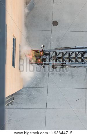 Firefighter Training Entering And Exiting A Building On A Truck Ladder Overhead View