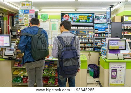 SEOUL, SOUTH KOREA - CIRCA MAY, 2017: men at a CU convenience store. CU is a convenience store franchise chain in South Korea.