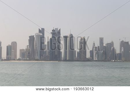 DOHA, QATAR - JULY 3, 2017: Doha's towers, seen across the humid Gulf waters as the Saudi ultimatum expired