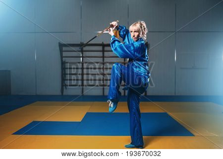 Female wushu fighter with sword in action