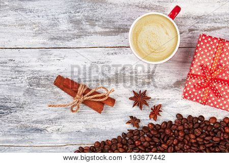 Cup of coffee, wooden background. Cinnamon and gift box. Be grateful with coffee.