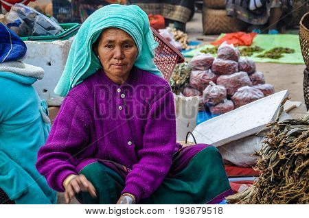 MUANG SING, LAOS - DECEMBER 28, 2012: Women selling vegetables in the morning market in the village of Muang Sing Laos