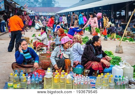 MUANG SING, LAOS - DECEMBER 28, 2012: Women selling vegetables in the morning market in the village of Muang Sing Laos