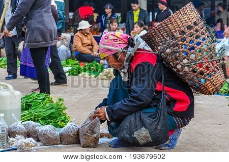 MUANG SING, LAOS - DECEMBER 28, 2012: Woman with a bag in the morning market in the village of Muang Sing Laos