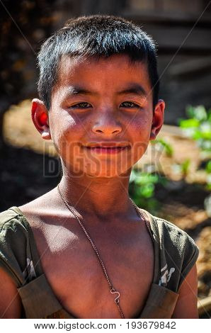 MUANG SING, LAOS - DECEMBER 28, 2012: Local boy in a small ethnic community near the village of Muang Sing in Laos