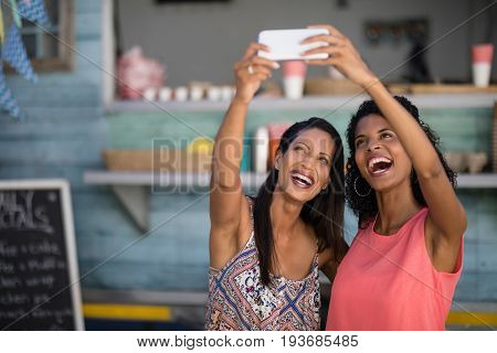 Happy friends taking selfie from mobile phone