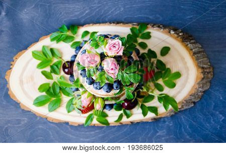 Naked wedding cake decorated with berries and flowers