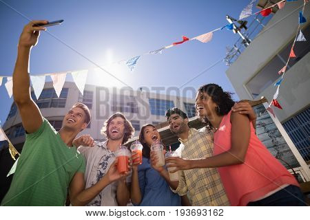 Happy friends taking selfie from mobile phone