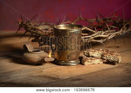 Table with crown of thorns and Communion elements and oil lamp