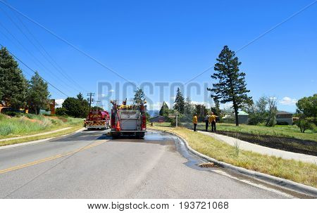 KALISPELL, MONTANA, USA - June 21, 2017: Fire crew observe grass fire scene as a water truck leaves the scene