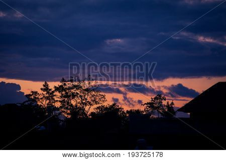 Silhouette of Asian house with a tiled roof against the sky with clouds sunset