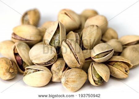 Heap of pistachio nuts isolated on white background close up, macro