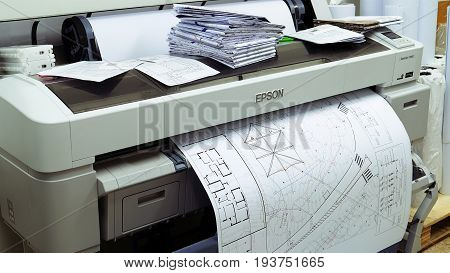 Jerusalem, Israel - May 21, 2017: Wide format printer is printing design draft outline sketch drawing in the printing house. Design office supply equipment.