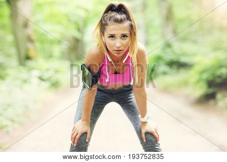 Exhausted woman jogging in the forest