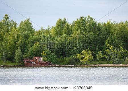 Old rusty sunken ship in water on coat