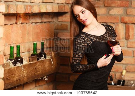 Woman Tasting Wine In Rural Cottage Interior