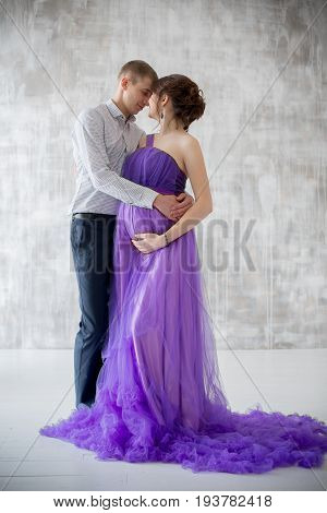 pregnant woman and man posing together in Studio, happy waiting