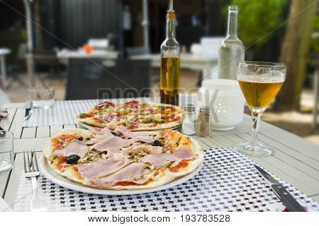 Pizza with ham and chorizo in Italian restaurant