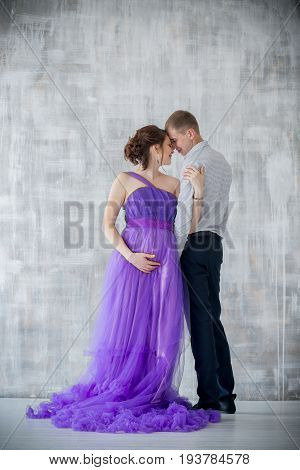 pregnant woman and man posing together in Studio, happy waiting