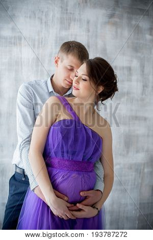pregnant woman and man posing together in Studio, happy waiting
