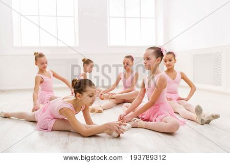Young ballerinas stretching before performance, classical dance school