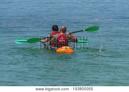 Labuan,Malaysia-May 1,2017:Group of tourist enjoying a weekend kayaking with the transparent kayak in Rusukan Besar island,Labuan,Malaysia.Labuan is the ideal place for water sports,like kayaking & scuba diving