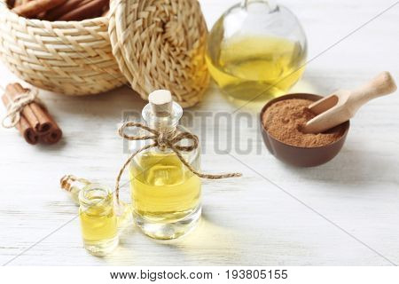 Composition with bottles of cinnamon oil on wooden background