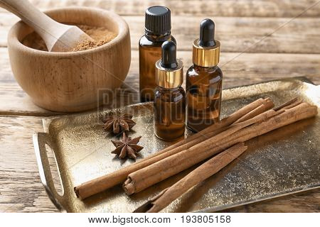 Composition with bottles of cinnamon oil on wooden background