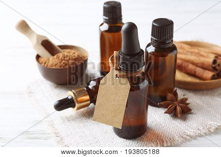 Composition with bottles of cinnamon oil on wooden background
