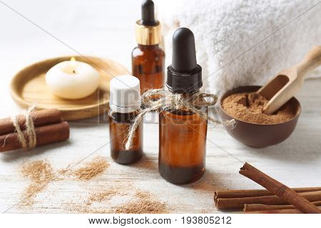 Composition with bottles of cinnamon oil on wooden background