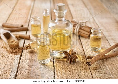 Composition with bottles of cinnamon oil on wooden background
