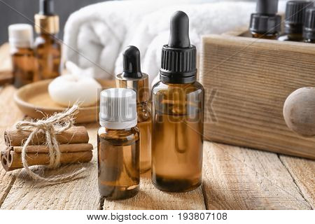 Composition with bottles of cinnamon oil on wooden background
