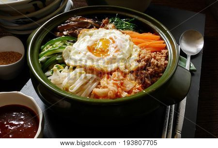 bibimbap, traditional korean food ,mixed rice served in a bowl rice topping alot kind of vegetable ,meat or pork, and fried egg