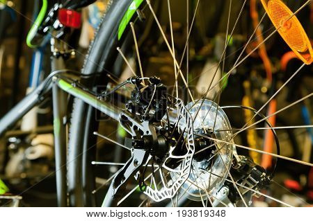 Disc brake on a black bicycle in the light of a flashlight