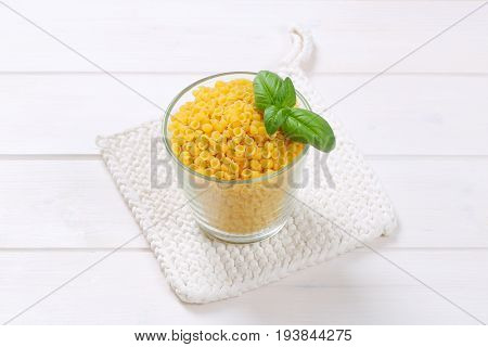 glass of small pasta shells on white table mat